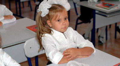 little girl sitting at desk in school