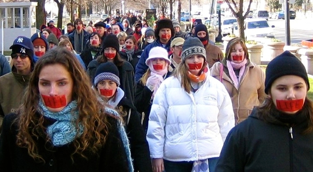 Crowd with tape over their mouth
