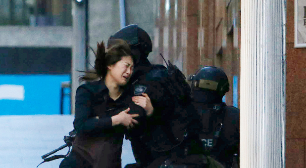 A woman flees a hostage situation in Sydney, Australia.