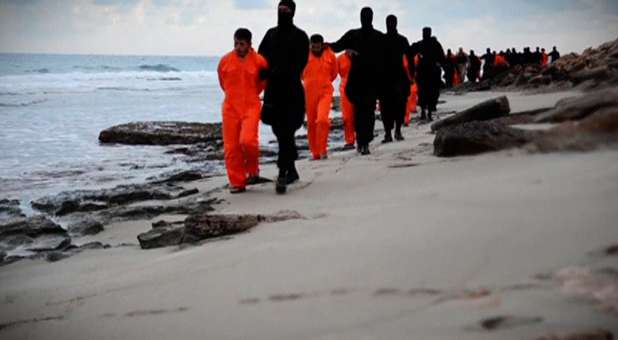 Men in orange jumpsuits purported to be Egyptian Christians held captive by the Islamic State (IS) are marched by armed men along a beach.
