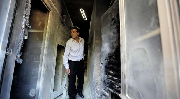 An Israeli man looks at damage at a Greek Orthodox seminary in Jerusalem.