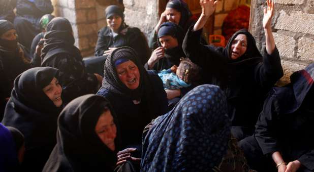 Relatives of Egyptian Coptic men killed in Libya mourn at their house in El-Our village