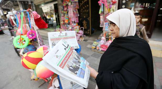 A Palestinian woman reads Israel's election results.