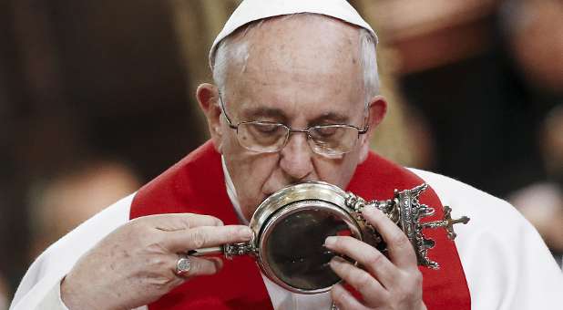 Pope Francis kisses the vial of what local Roman Catholics believe is the blood of Saint Gennaro.