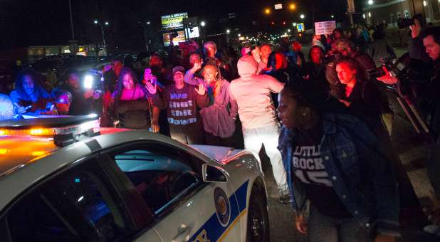 Protesters block a police vehicle from entering the City of Ferguson Police Department and Municipal Court parking lot in Ferguson Missouri.