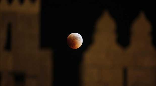 A blood moon viewed through the wall of Damascus gate in Jerusalem's Old City during a total lunar eclipse, June 15, 2011