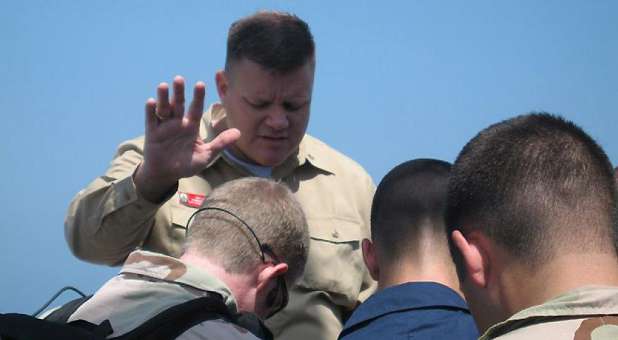 Navy Chaplain Wes Modder prays over soldiers.