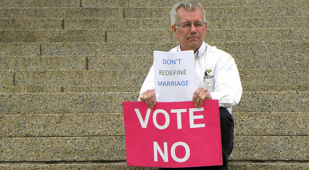 A man protests gay/redefining marriage.