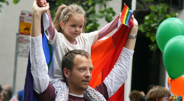 A father and daughter at a gay pride parade.