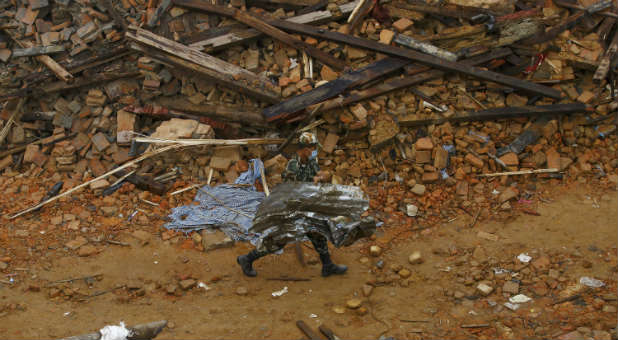 A member of the Nepalese army helps clear debris after the Nepal earthquake.
