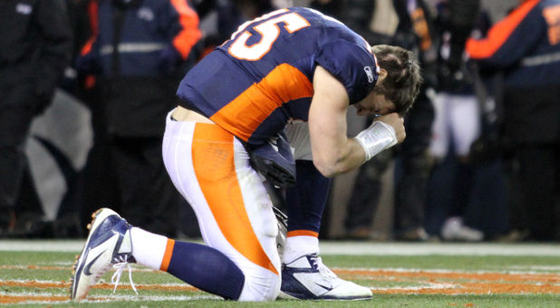 Tim Tebow prays after a Broncos game in Denver, Jan. 8, 2012.