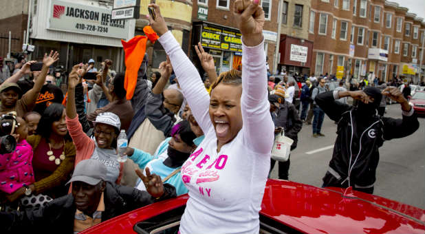 People celebrate in the streets of Baltimore after hearing that police will be charged with murder, other charges in Freddie Gray's death.
