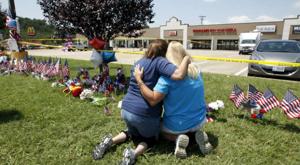 Friends embrace at the make-shift memorial set up for the victims of the Chattanooga shooting.