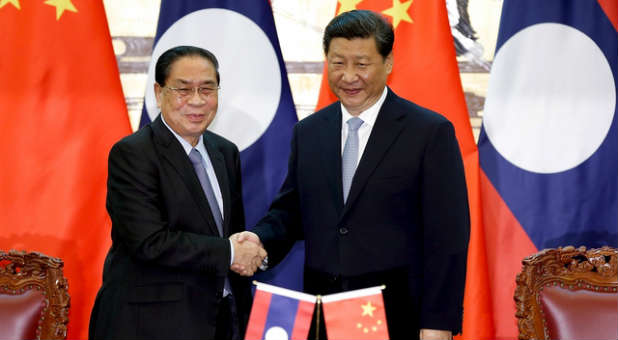 Chinese President Xi Jinping (R) shakes hands with Laos' President Choummaly Sayasone during the signing ceremony at the Great Hall of the People in Beijing, China. A Laos pastor was reportedly recently killed for his faith.