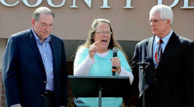 Kim Davis, center, is flanked by Mike Huckabee, left, and attorney Mat Staver, right, after her release from jail.