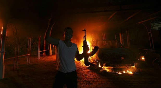 A protester reacts as the U.S. Consulate in Benghazi is seen in flames.