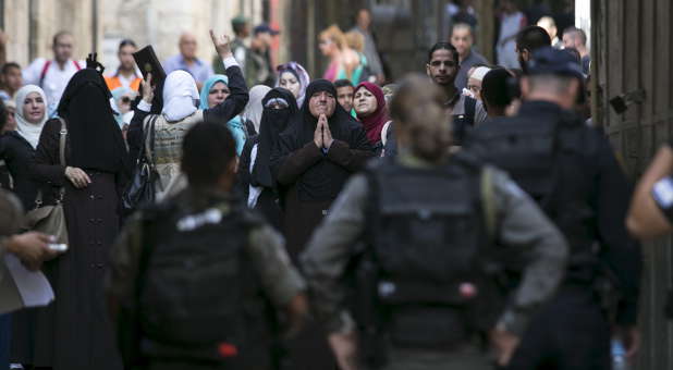 Muslim women shouts slogans as they protest in front of Israeli border police officers in Jerusalem's Old City, Sept. 15, 2015. Violence in the city of Jerusalem has increased, prompting some groups to form prayer shields over the city.