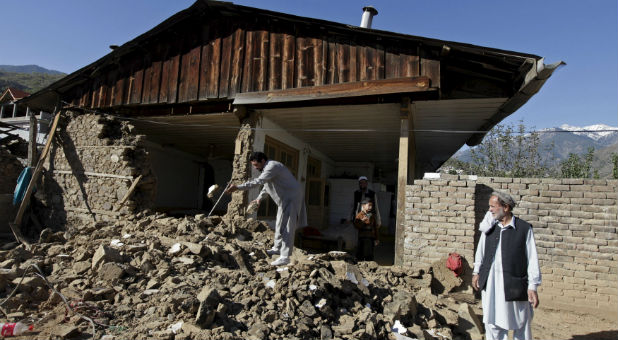 A man picks through rubble after an earthquake.