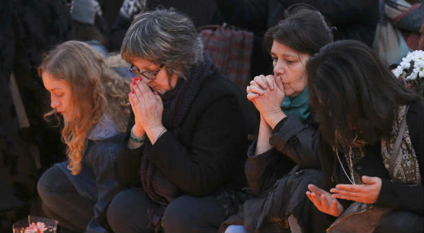 Women pray at a memorial in Paris.