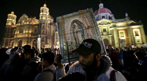 A pilgrim holds up an image of the Virgin of Guadalupe at the Basilica of Guadalupe during the annual pilgrimage in honor of the Virgin of Guadalupe, in Mexico City.