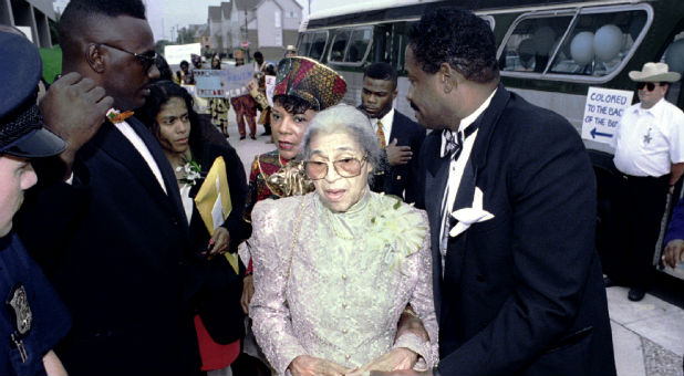 Men assist Rosa Parks into the African-American Museum of History. Parks sparked the Montgomery bus boycott 60 years ago.