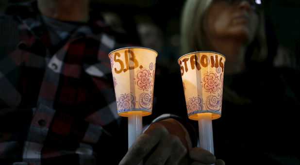 Men and women participate in a prayer vigil for the San Bernardino victims.
