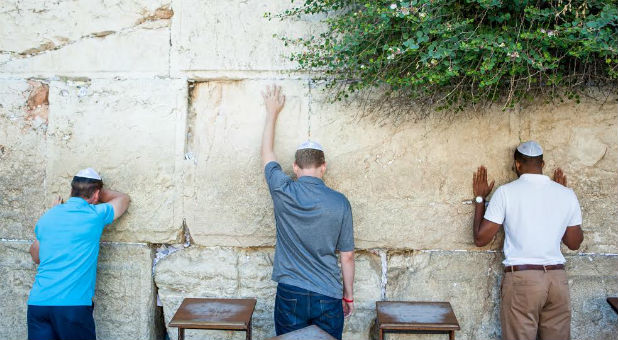 Men wait on God at the Western Wall in Jerusalem.