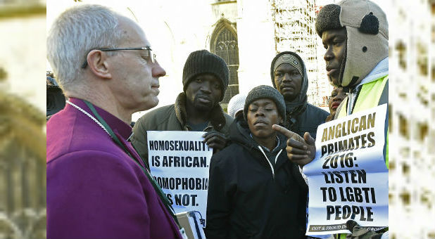 Archbishop of Canterbury Justin Welby, left, speaks with protesters on the grounds of Canterbury Cathedral in Canterbury, England.