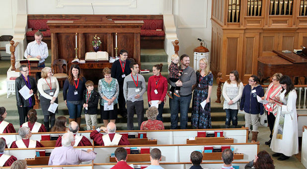 Pastor Robin Bartlett, far right, conducts a new-member ceremony at First Church.