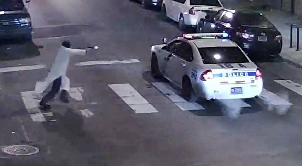 A still image from surveillance video shows a gunman (L) approaching a Philadelphia Police vehicle in which Officer Jesse Hartnett was shot shortly before midnight January 7, 2016.