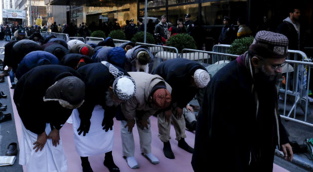 Muslim men pray outside Donald Trump's office in protest.
