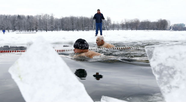 People react as they take a dip in a lake during Orthodox Epiphany celebrations.