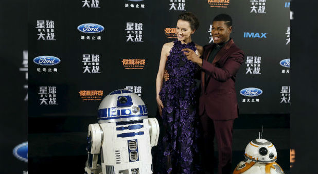 Cast members Daisy Ridley and John Boyega pose for pictures with Star Wars characters BB-8 and R2-D2 at the China Premiere of the film