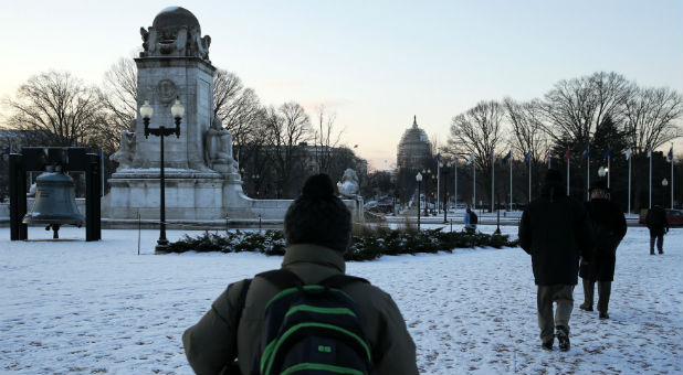 Commuters make their way towards the U.S. Capitol from Union Station on a chilly morning after a light snow fell in Washington