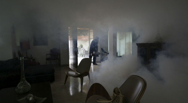 A worker fumigates a house in an area affected by the Zika virus.
