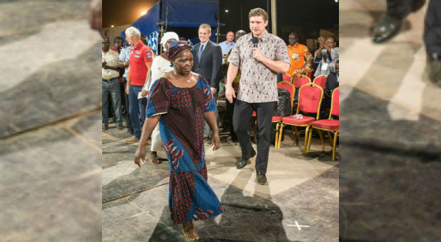 Daniel Kolenda with a woman who was healed of paralysis.