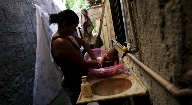 A Brazilian mother bathes her child with microcephaly, believed to be a result of the Zika virus.