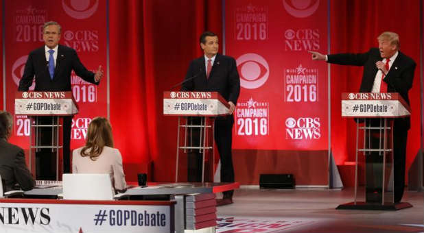 Republican presidential candidates Jeb Bush and Donald Trump speak at the same time as they debate the record of Bush's brother, as Ted Cruz looks on.