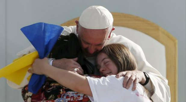 Pope Francis hugs two girls during a meeting with youths at the Jose Maria Morelos y Pavon stadium in Morelia, Mexico,