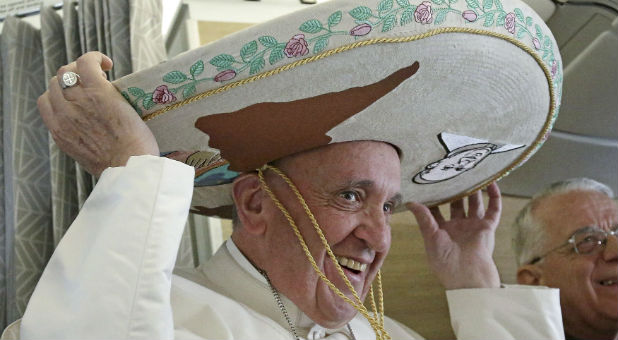 Pope Francis wears a Sombrero he received as a gift from a Mexican journalist aboard an airplane to Havana.