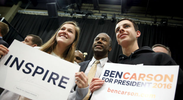 Republican U.S. presidential candidate Ben Carson takes a photo with Claire Birchmier, 17, and Brandon Short, 18, both of Carlisle, Iowa, after speaking at a Trust in God town hall at Simpson College in Indianola, Iowa.