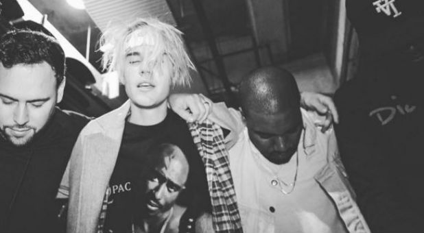 Justin Bieber prays with Uncle Puff and Kanye West.
