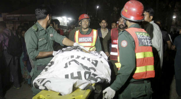 Rescue workers move a body from the site of a blast outside a public park in Lahore, Pakistan.