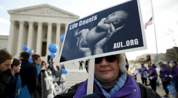 Pro-life advocates protest abortion outside the Supreme Court.