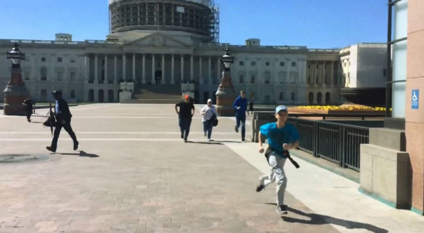 Tourists run for safety past the entrance to the U.S. Capitol Visitors Center after shots are fired.