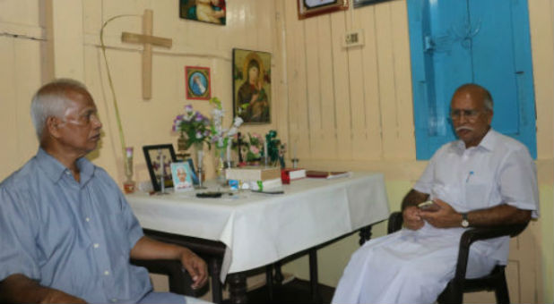 Mathew Uzhunnalil, left, the older brother of kidnapped priest Thomas Uzhunnallil, talks with their cousin, V.A. Thomas, in the family home in Kerala state, India.