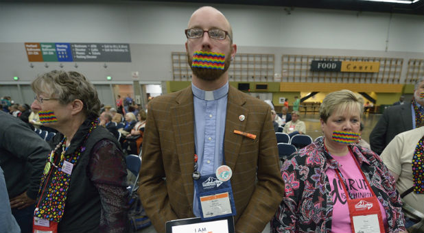 Demonstrators wear rainbow gags on May 14, 2016, to protest what they believe is an attempt to silence LGBTQ voices during the 2016 United Methodist General Conference in Portland, Ore. The silent protest took place at the edge of a plenary session of the conference.
