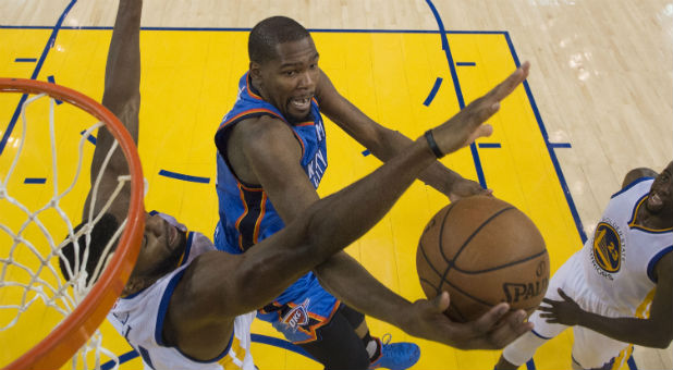 Oklahoma City Thunder forward Kevin Durant (35, center) shoots the basketball against Golden State Warriors center Festus Ezeli (31, left) during the second half in game two of the Western conference finals of the NBA Playoffs