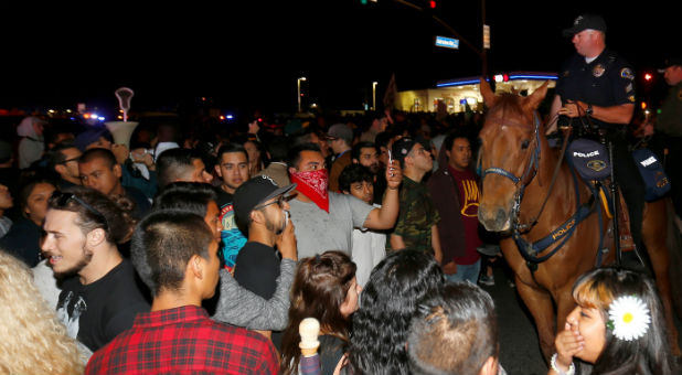 Police on horseback break up a demonstration outside Republican U.S. presidential candidate Donald Trump's campaign rally in Costa Mesa
