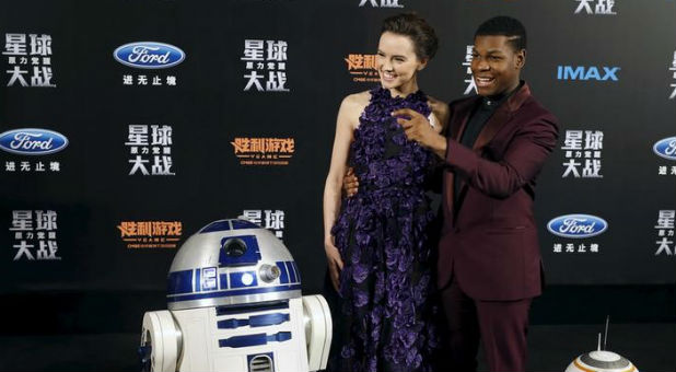 Cast members Daisy Ridley and John Boyega pose for pictures
